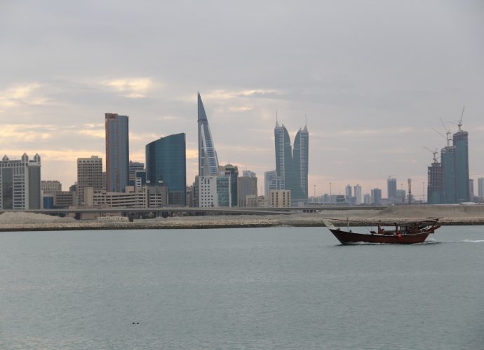 a boat in a body of water with a city in the background