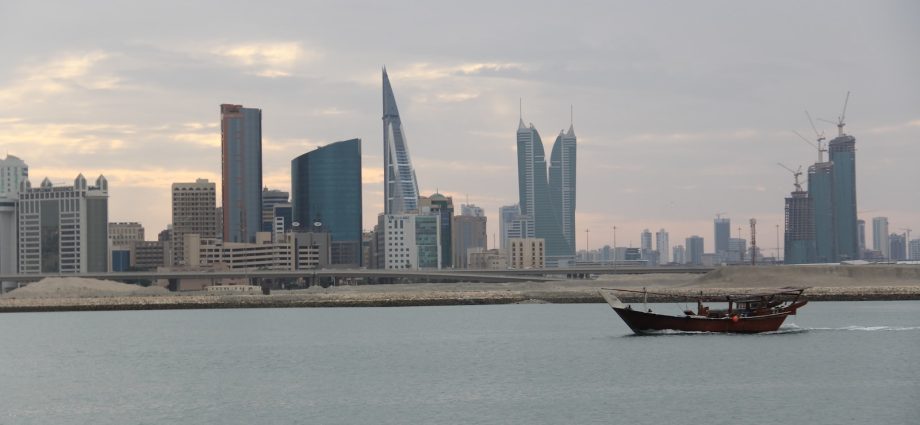 a boat in a body of water with a city in the background